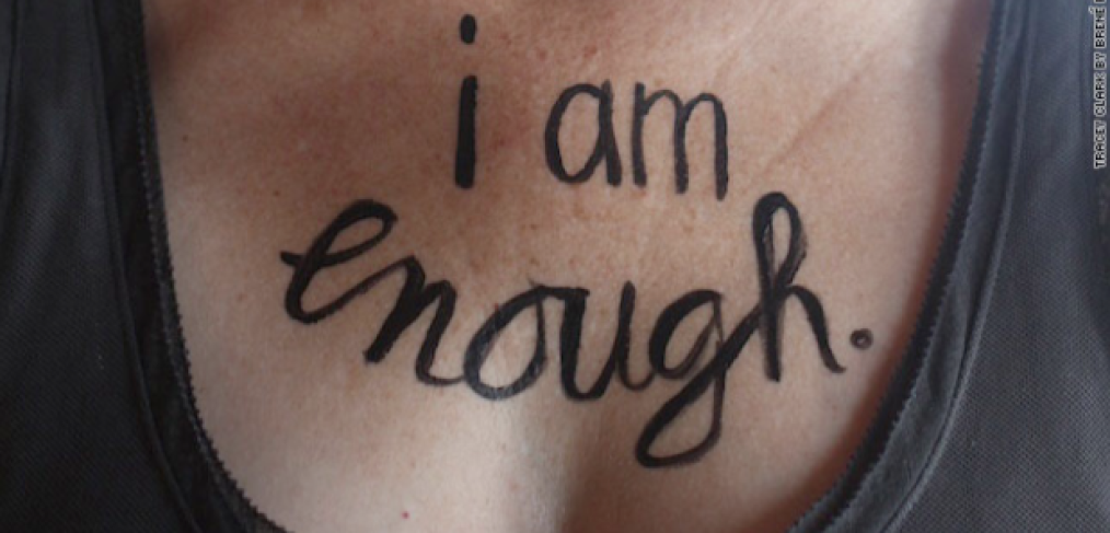 brene brown photo showing I am Enough written on a woman's chest